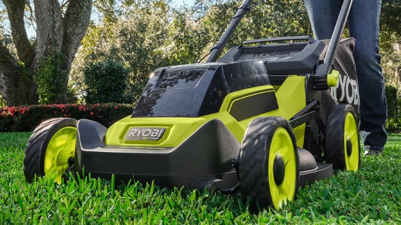 Person mowing lawn with Ryobi mower