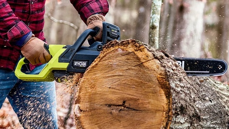 Person cutting log with Ryobi 20-inch chainsaw