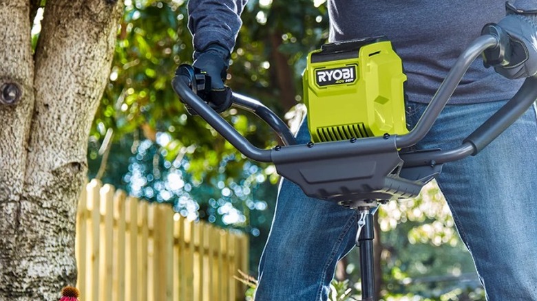 Person using Ryobi post hole auger