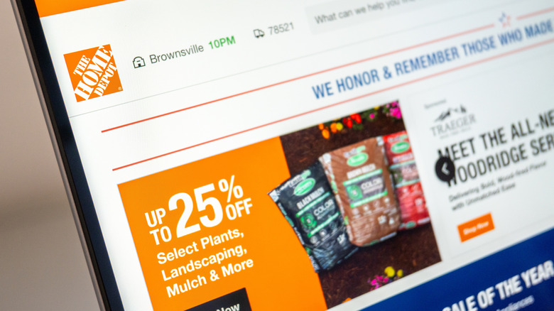 A laptop showing the Home Depot website with a 25% off deal for plants and landscaping displayed