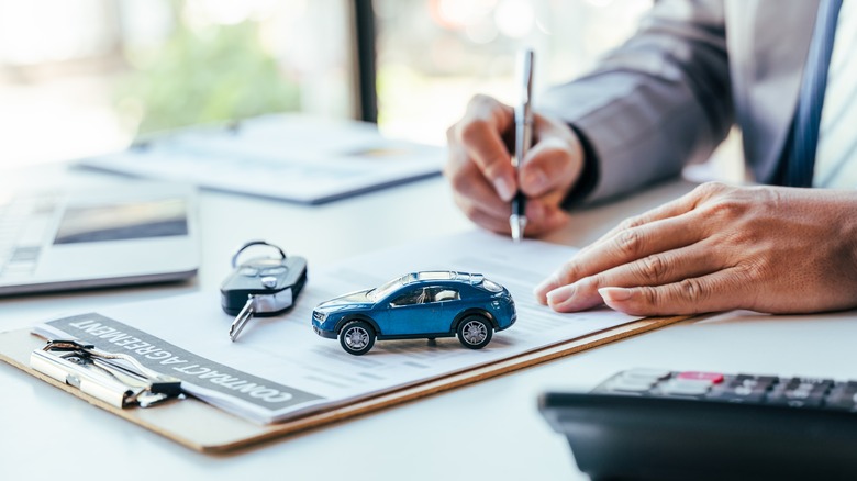 car dealer filling out paperwork