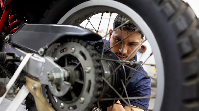 Close up of a man inspecting motorcycle tire