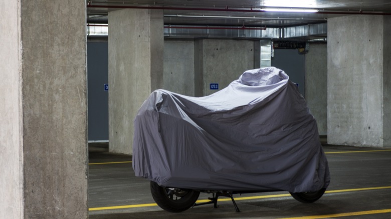 Close up of a covered motorcycle in a garage
