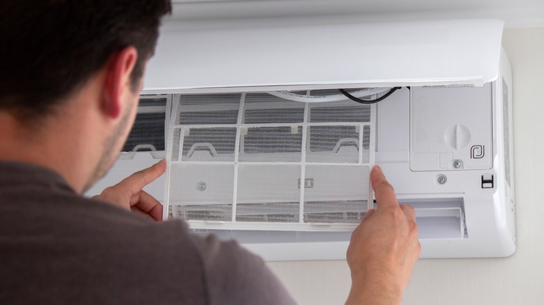 Man installing a clean filter in AC