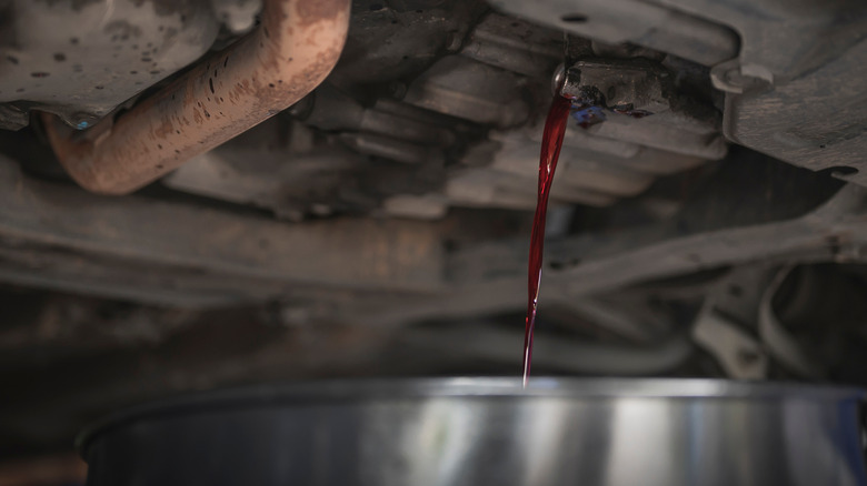 Bright red transmission fluid draining into a pan