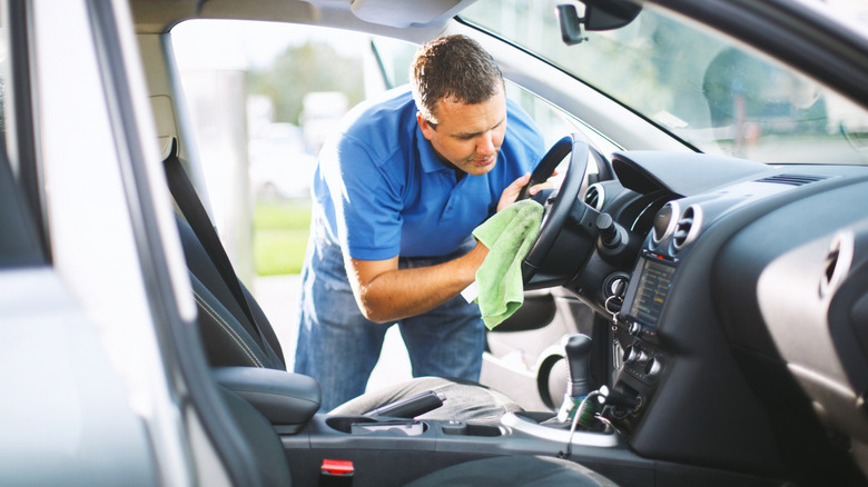 Man wipes the steering wheel