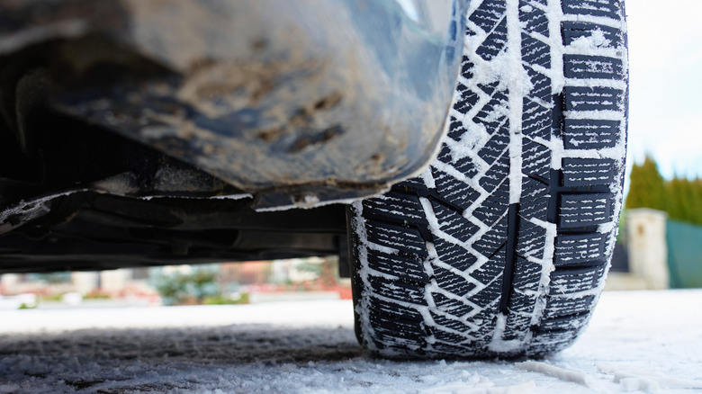 Close up of car tire and underside in the snow.