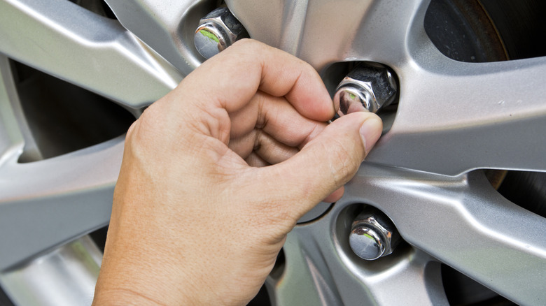 Replacing the lug nuts of a car.