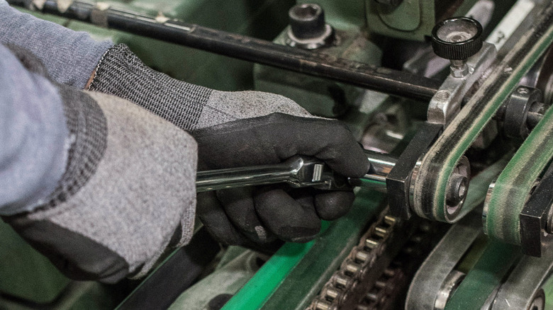 Mechanic using a Gray ratchet to work on a machine belt
