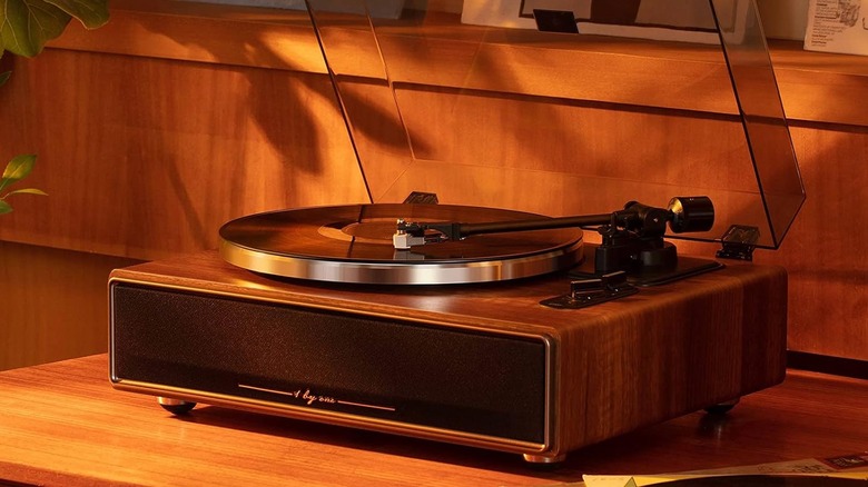 A record player on a desk with a song playing.