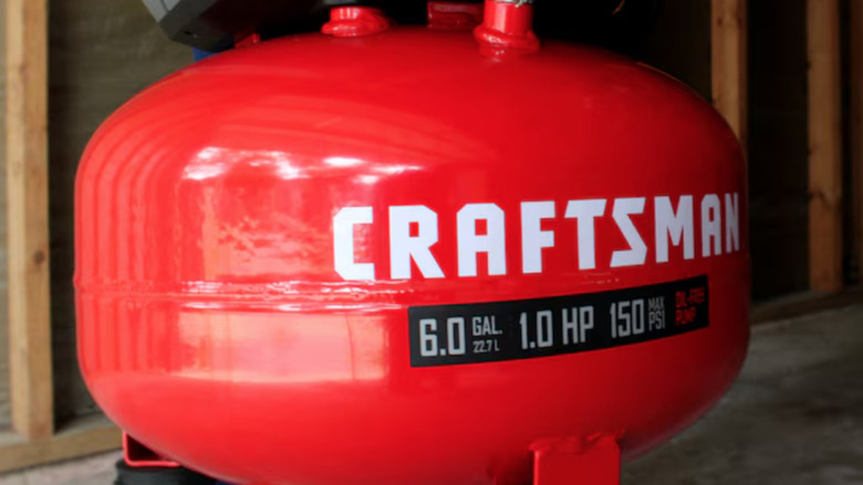 Close-up of 6-gallon pancake air compressor in man's hand