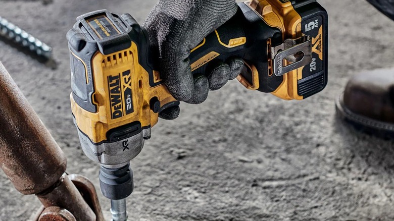 A person using a DeWalt impact wrench on a bolt.