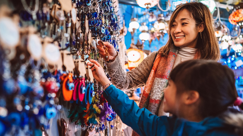 Parent and child browsing through keychains in a shop.