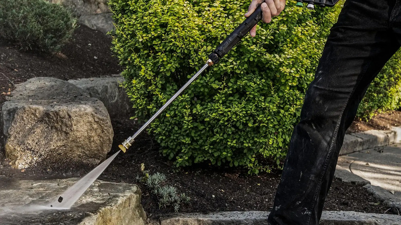 A man pressure washing a concrete staircase with a DeWalt pressure washer
