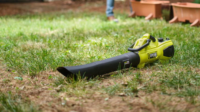 A Ryobi leaf vacuum laying in the grass