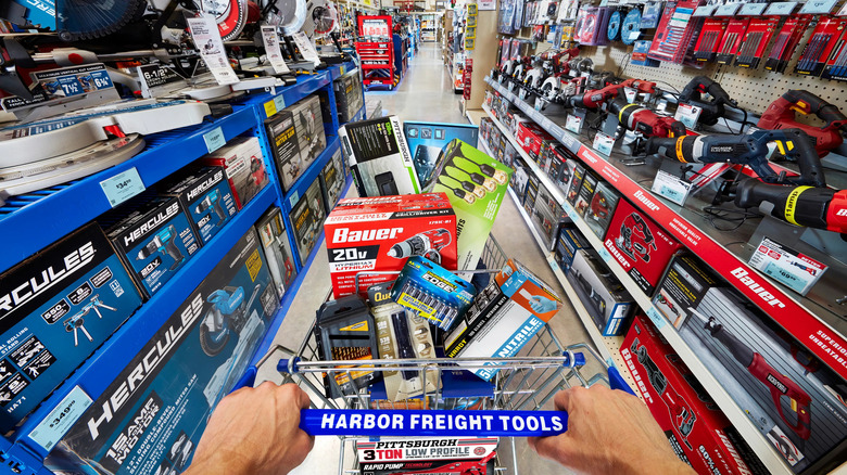 Shopping cart with Harbor Freight tools being pushed in an aisle