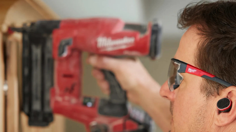 Worker using Milwaukee jobsite ear buds