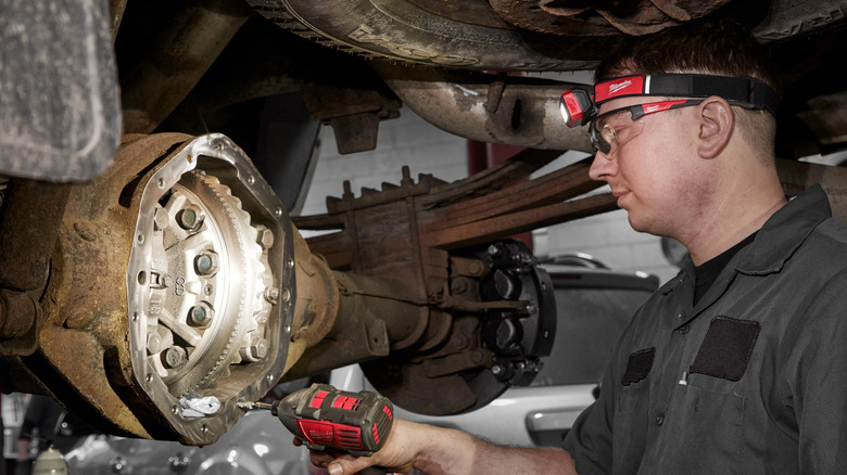 Mechanic working on car while wearing Milwaukee magnetic headlamp