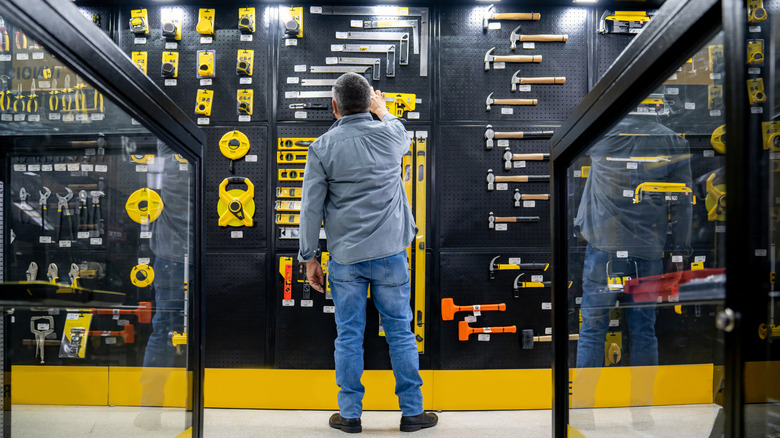 man looking at tools in a hardware store