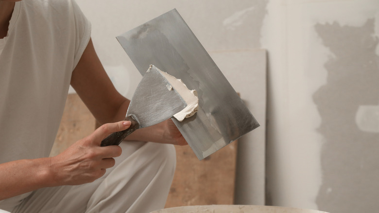a trowel and putty knife in use