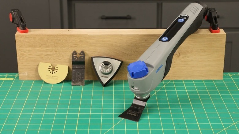 Dremel Blueprint 12V Oscillating Multi-Tool and attachments resting against a wooden block