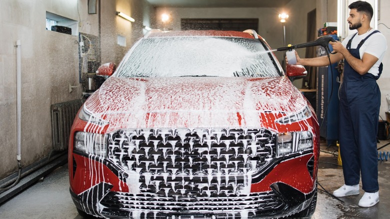 Man cleaning car with foam cannon