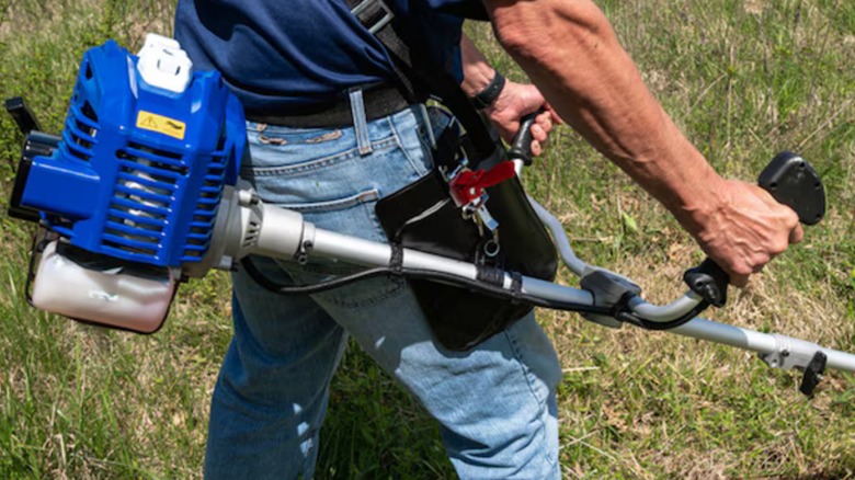a person using the wild badger power gas trimmer