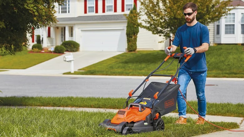 A person using the Black+Decker lawnmower.