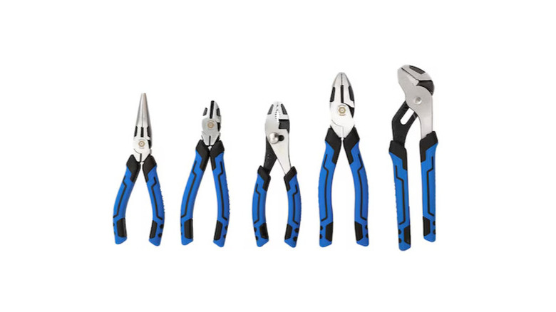 Four pliers leaning against wooden boards, with a wooden background behind them