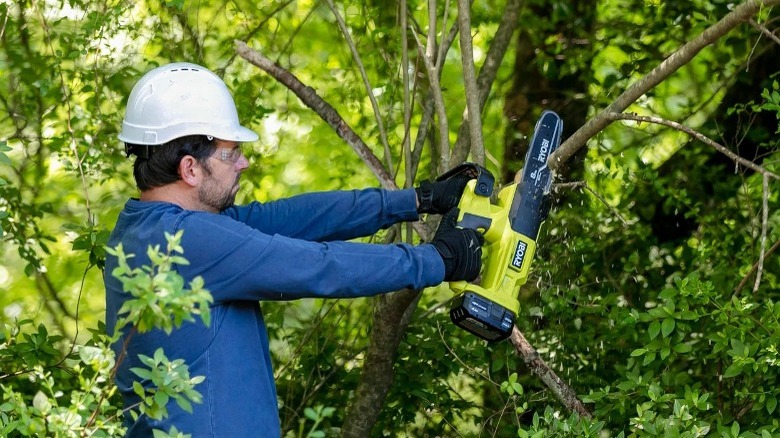 Person using mini chainsaw