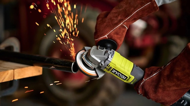 Person using Ryobi grinding tool on a steel pole