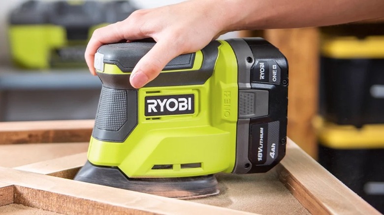 Person using Ryobi Corner Cat Finish Sander