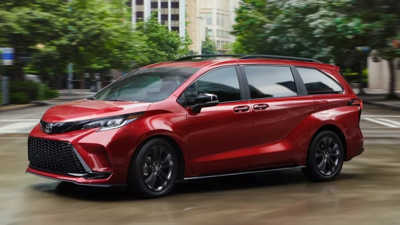 A red Toyota Sienna moving through an urban intersection