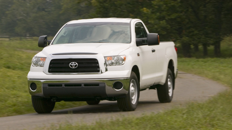 Front view of white Toyota Tundra driving on country road.