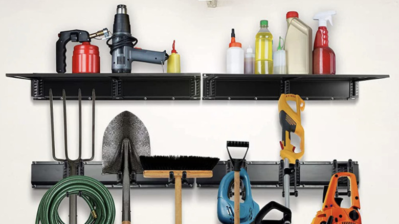 A close up of yard tools held on a storage rack and storage shelves