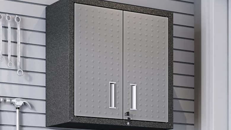 The Manhattan Comfort Fortress Floating Garage Cabinet installed on a pegboard wall