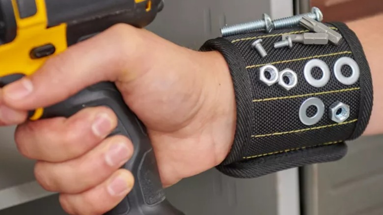A person wearing a Wrap-It magnetic wristband while using a drill.
