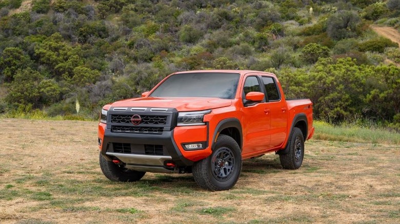 Red 2026 Nissan Frontier parked in wooded terrain