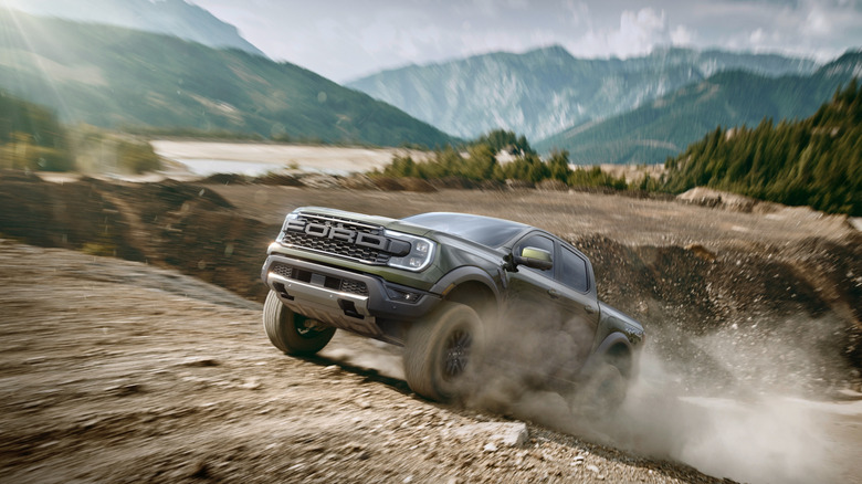 2026 Ford Ranger driving at speed off-road in forest terrain on dirt road, front-left 3/4 view