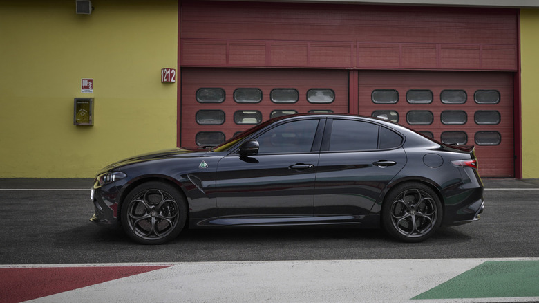 Side view of black  Alfa Romeo Giulia Quadrifoglio parked at race track.