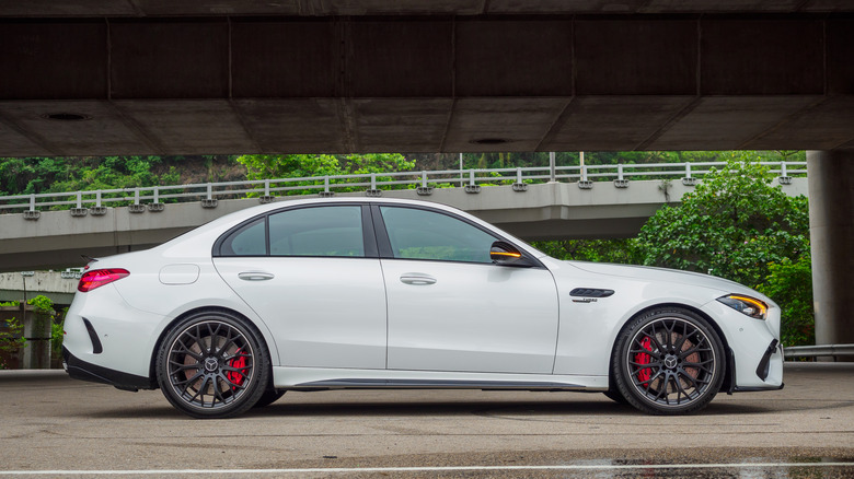 Side view of white Mercedes-AMG C63 parked beneath an overpass