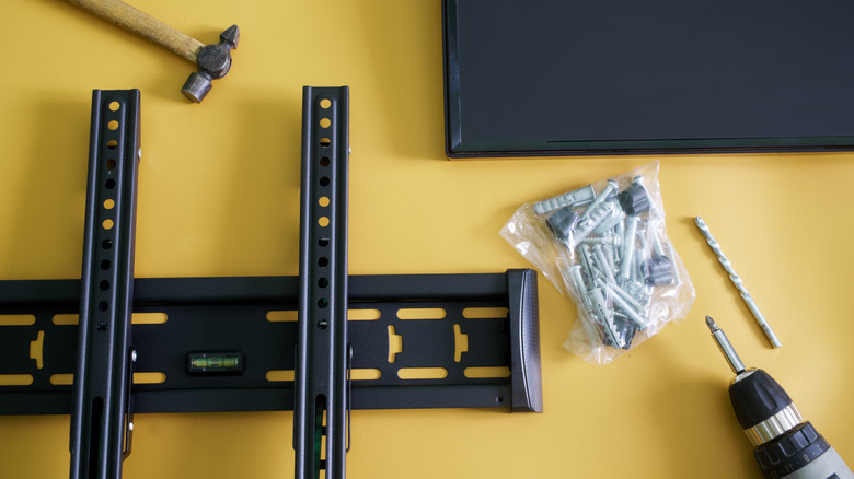 Different tools required for wall mounting a TV along with the mount