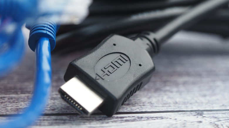 Various HDMI cables and connectors arranged on a wooden table.