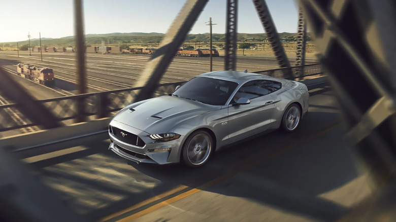 A silver 2023 Ford Mustang driving