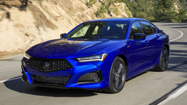 Blue Acura TLX driving on a road
