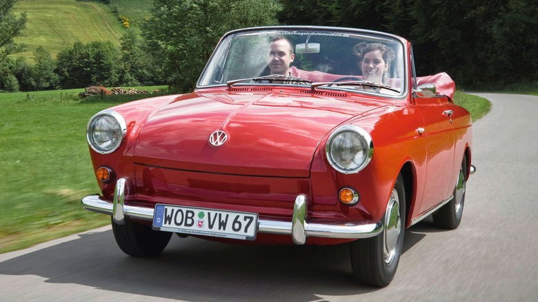 Front 3/4 view of VW 1500 convertible driving through countryside