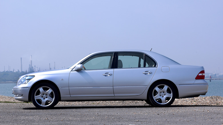 Side view of silver Lexus LS 430 parked near harbor.