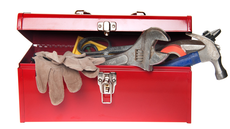 red tool box with tools hanging out