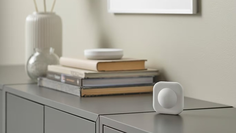 Wireless motion sensor on table with books and vases