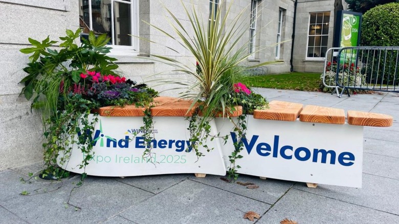 A planter made from a wind turbine blade outside.